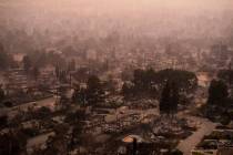 Smoke lingers over a neighborhood devastated by the Eaton Fire, Thursday, Jan. 9, 2025, in Alta ...