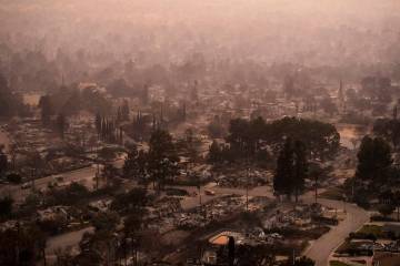 Smoke lingers over a neighborhood devastated by the Eaton Fire, Thursday, Jan. 9, 2025, in Alta ...