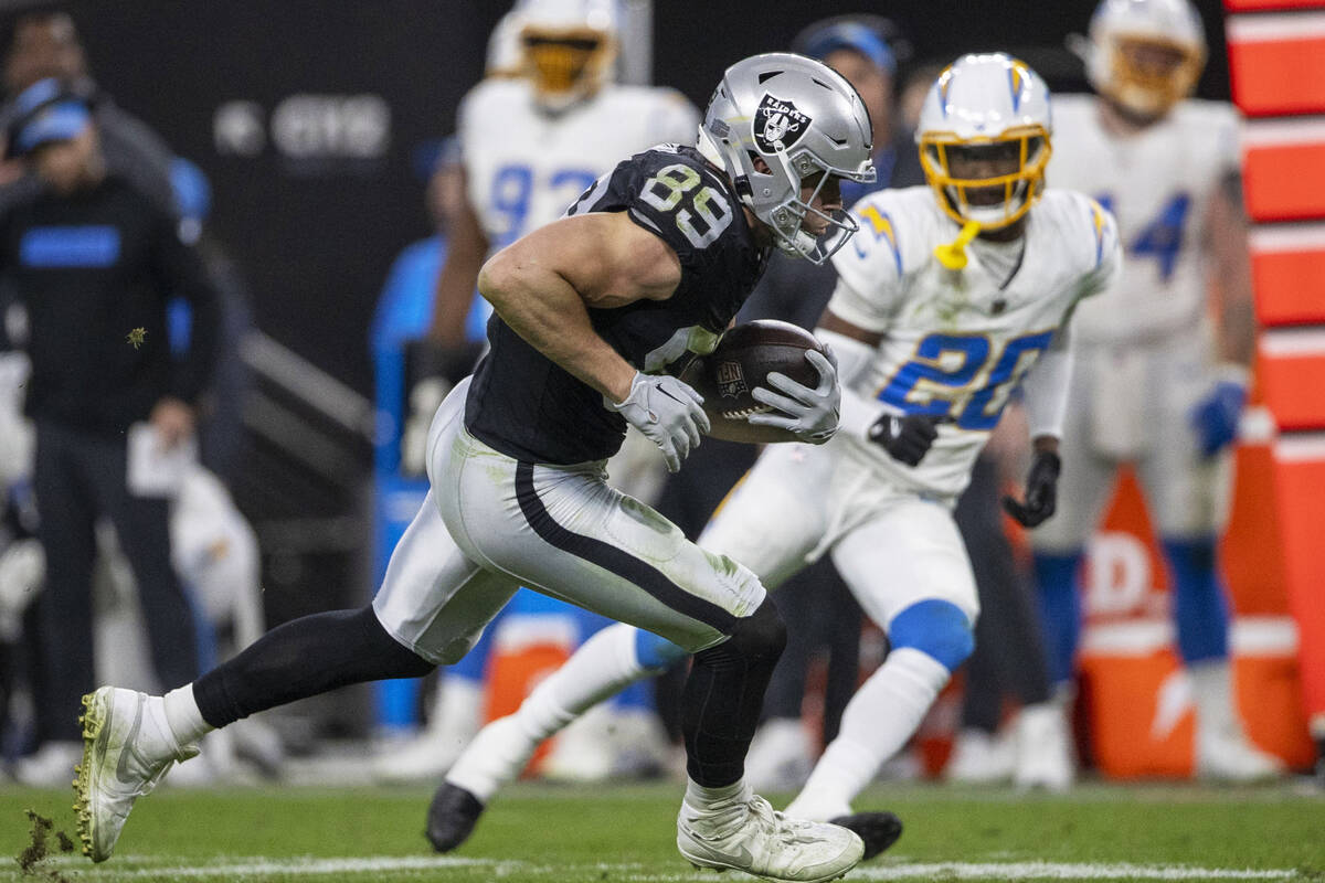 Raiders tight end Brock Bowers (89) looks to run past Los Angeles Chargers cornerback Cam Hart ...