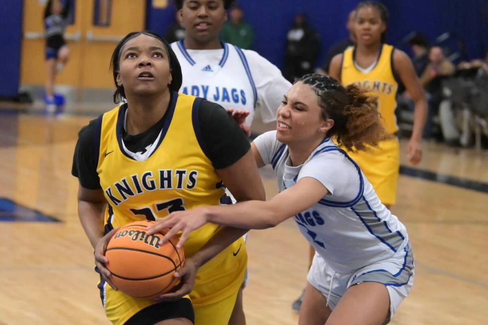 Democracy Prep's Heaven Spencer drive past Desert Pines' Mya Harper during their NIAA basketbal ...