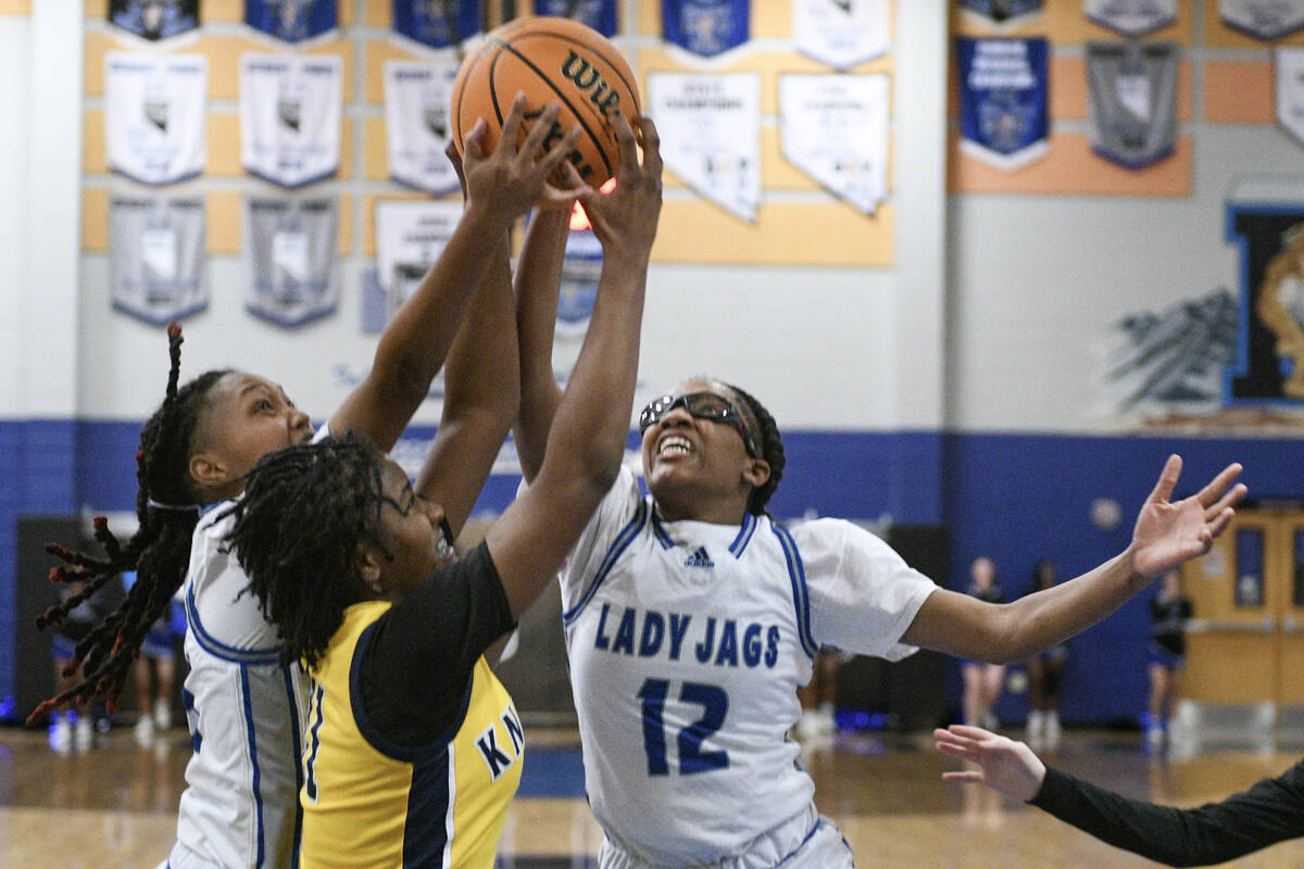 Desert Pines' Alyvia Harrington, left, and Desert Pines' Aaliyah Holman vie for a rebound again ...