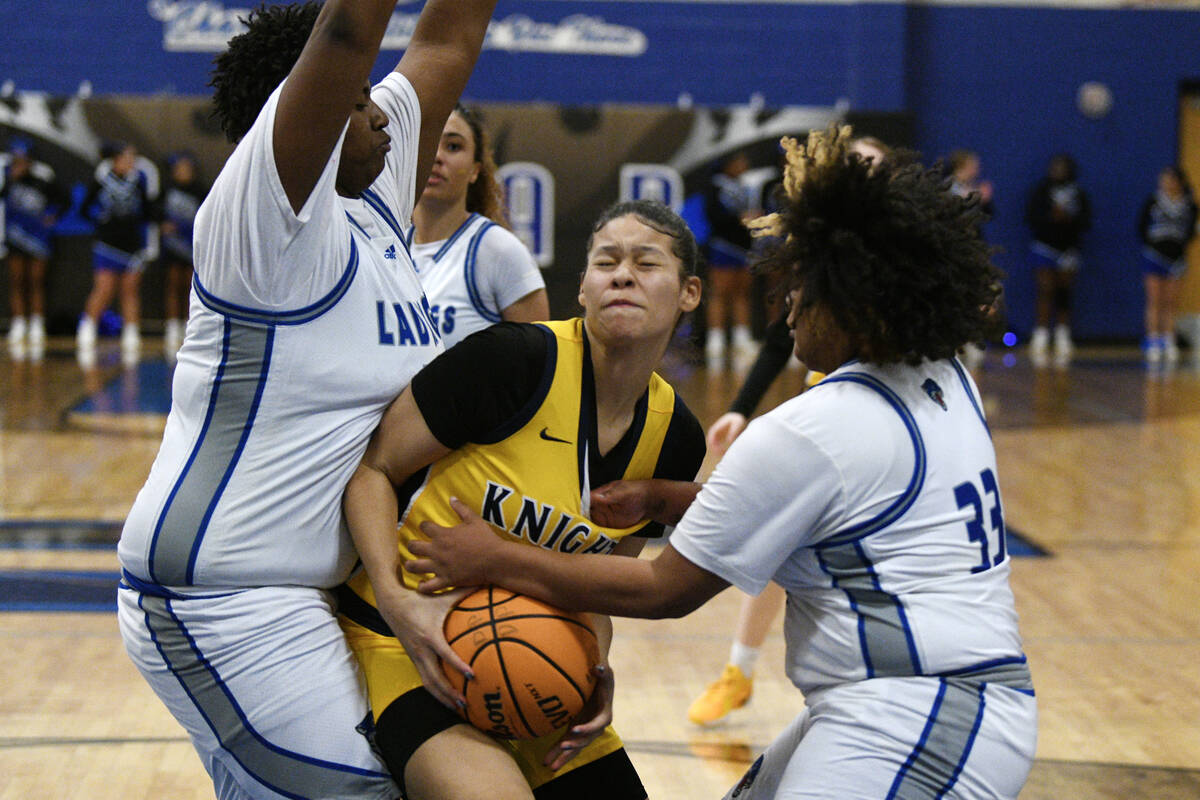 Democracy Prep's Brooklyn Williams drives between Desert Pines' Anaiah Brown, left, and Ashanti ...