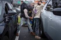 A deportation officer with U.S. Immigration and Customs Enforcement handcuffs Wilmer Patricio M ...