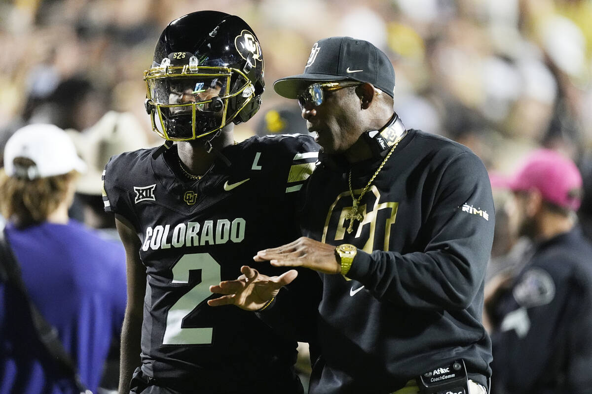 Colorado head coach Deion Sanders confers with his son, quarterback Shedeur Sanders, in the fir ...