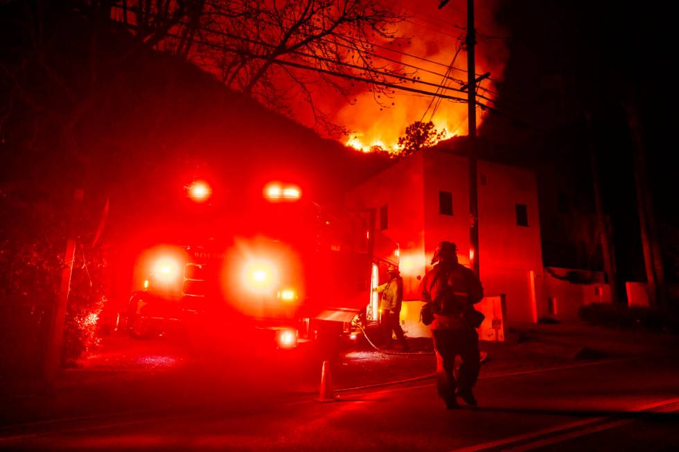 Firefighters set up to defend houses threatened by the Palisades Fire in Mandeville Canyon, Fri ...