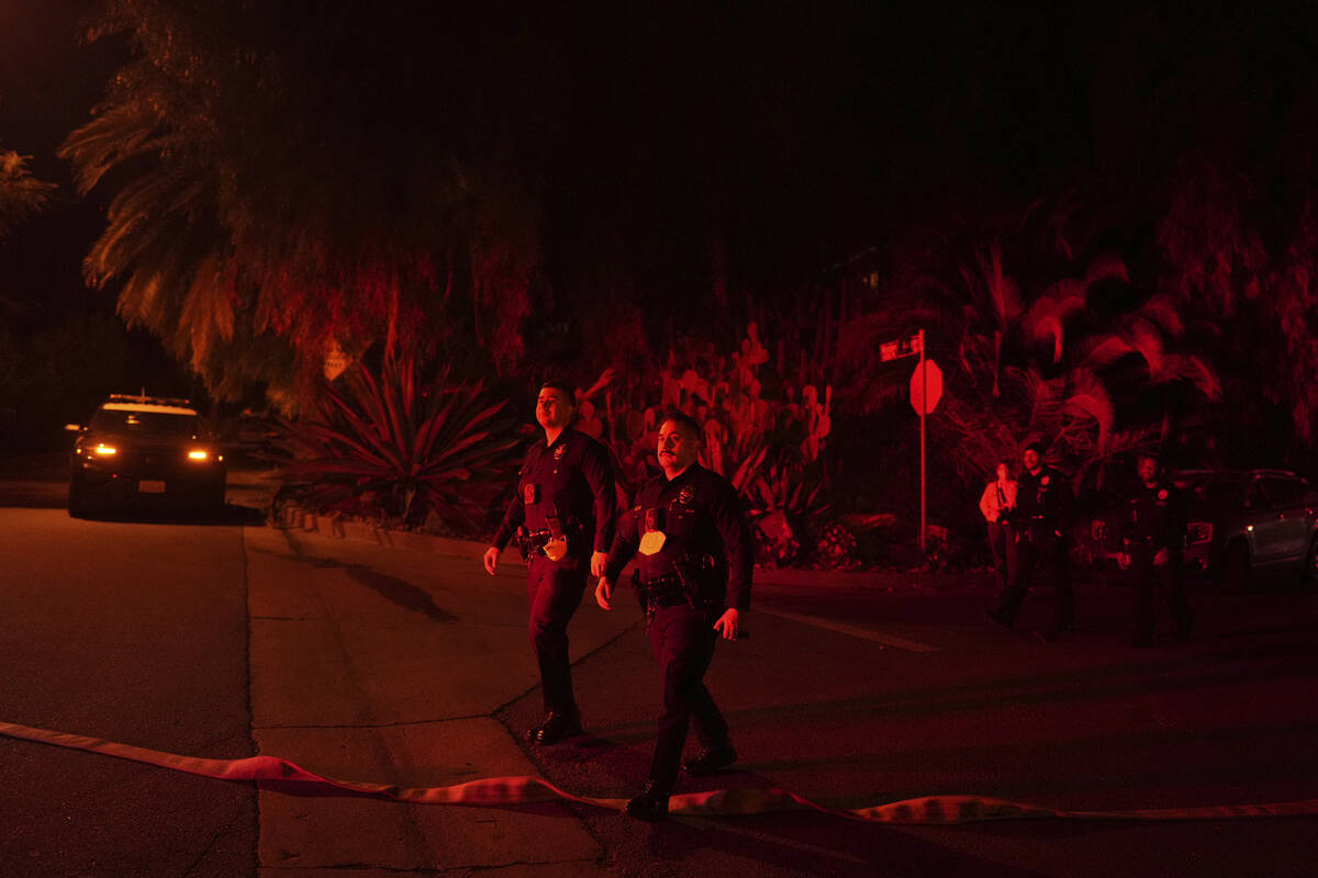 Police officers check on homes to evacuate residents near the Palisades Fire in Mandeville Cany ...