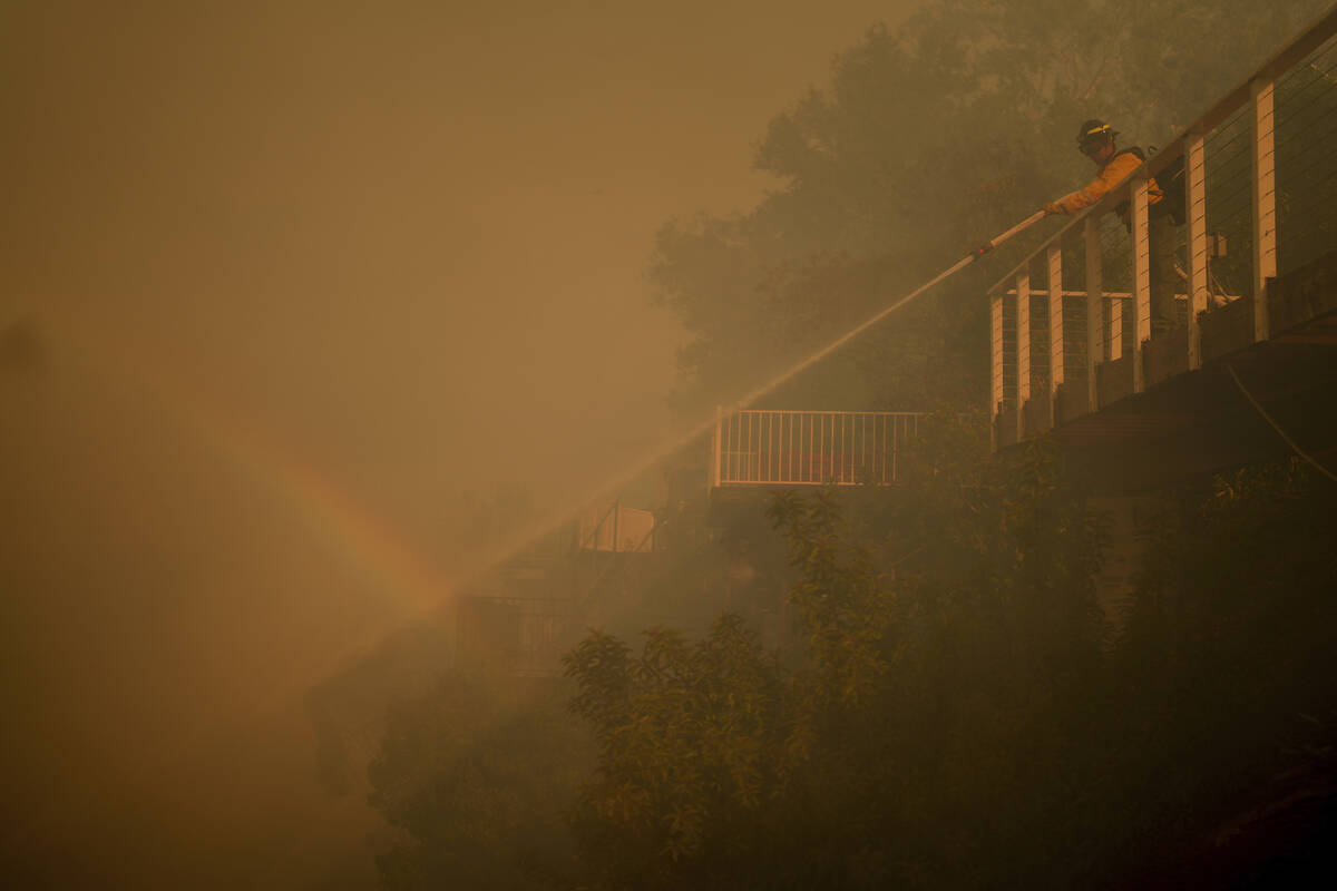 A firefighter battles the Palisades Fire from a deck in Mandeville Canyon Saturday, Jan. 11, 20 ...