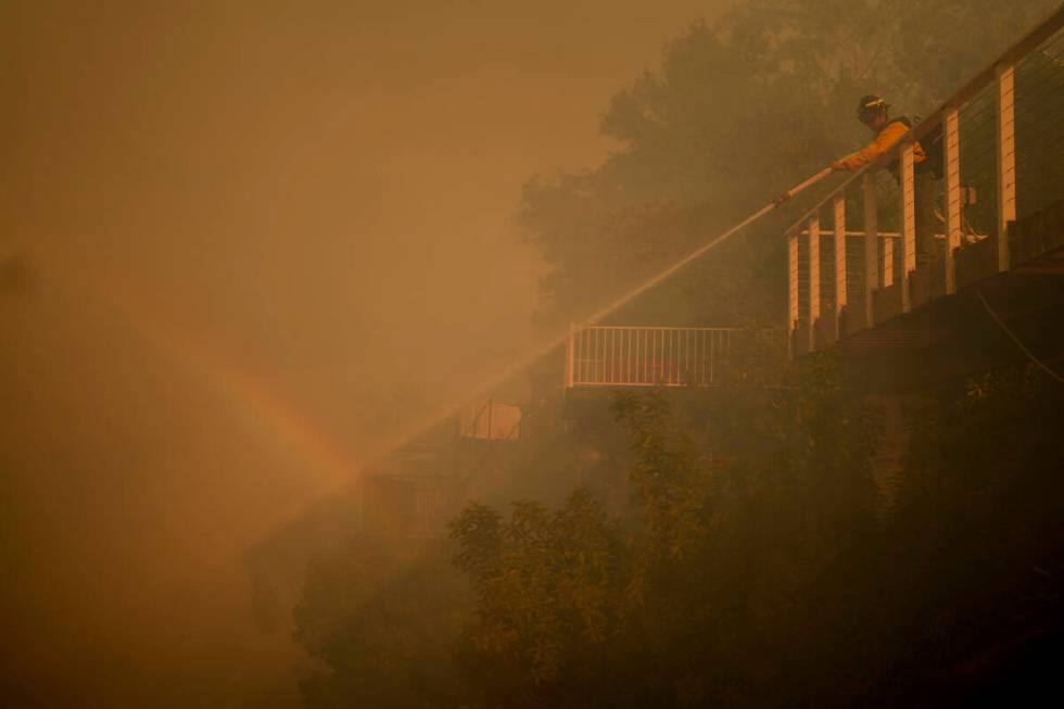 A firefighter battles the Palisades Fire from a deck in Mandeville Canyon Saturday, Jan. 11, 20 ...