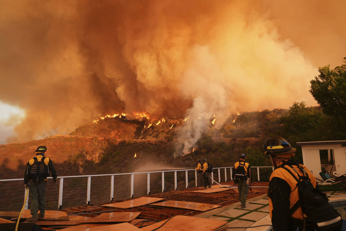 Fire crews monitor the Palisades Fire in Mandeville Canyon on Saturday, Jan. 11, 2025, in Los A ...