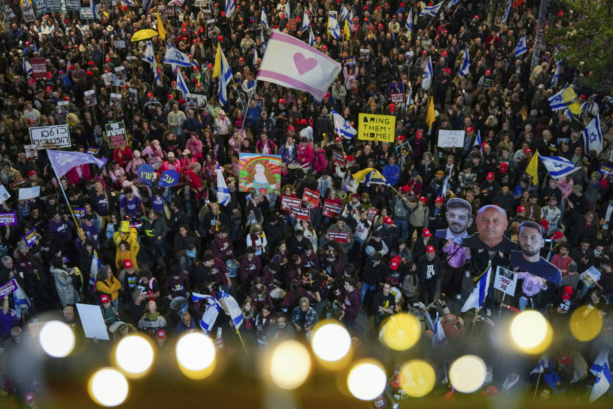 Demonstrators wave Israeli flags and signs during a protest calling for the immediate release o ...