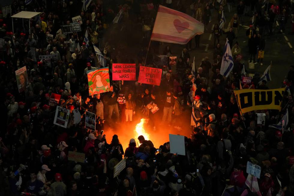 Demonstrators light a bonfire during a protest demanding a cease-fire deal and the immediate re ...