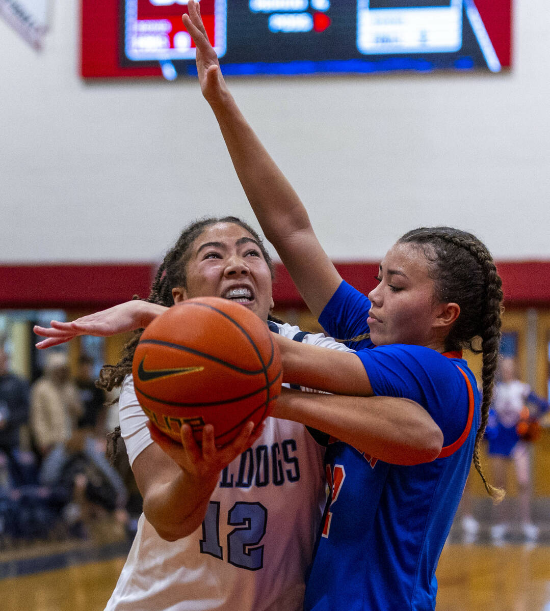 Centennial's forward Ayla Williams (12) is fouled but still shoots under Bishop Gorman's guard ...