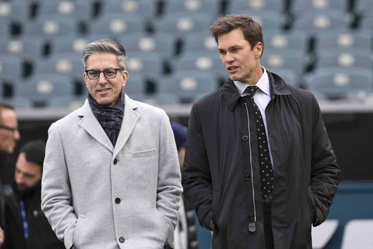 NFL play by play analyst Kevin Burkhardt, left, walks on the field with his broadcast partner a ...