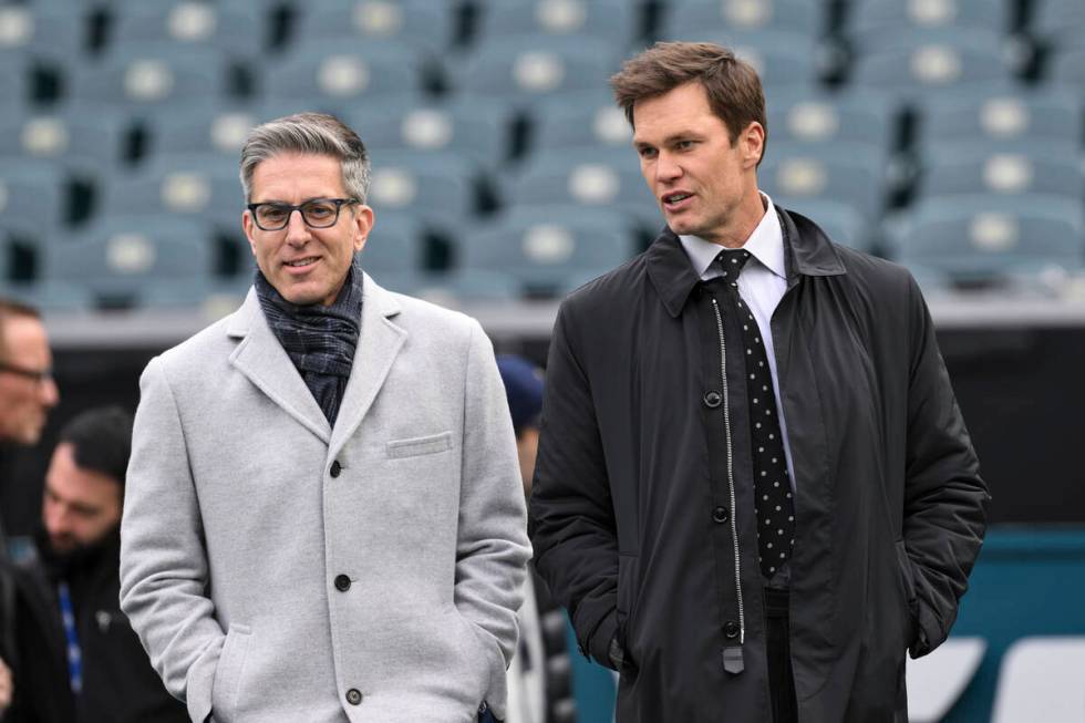 NFL play by play analyst Kevin Burkhardt, left, walks on the field with his broadcast partner a ...