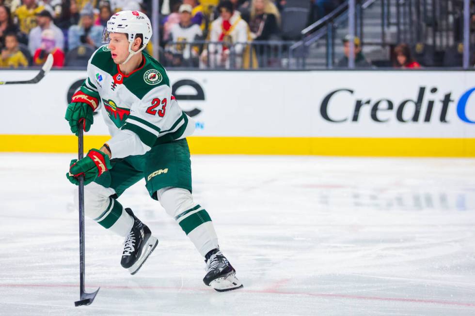 Minnesota Wild center Marco Rossi (23) shuffles the puck back across the ice during an NHL hock ...