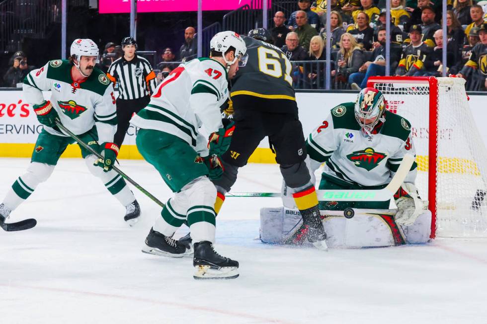 Minnesota Wild goaltender Filip Gustavsson (32) wards off an attempted shot by Golden Knights r ...