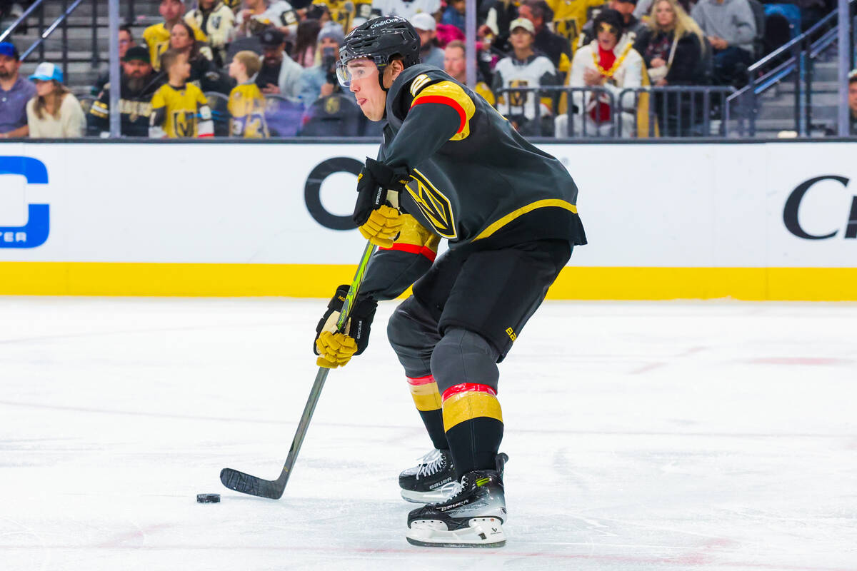 Golden Knights defenseman Zach Whitecloud (2) slides the puck down the ice during an NHL hockey ...