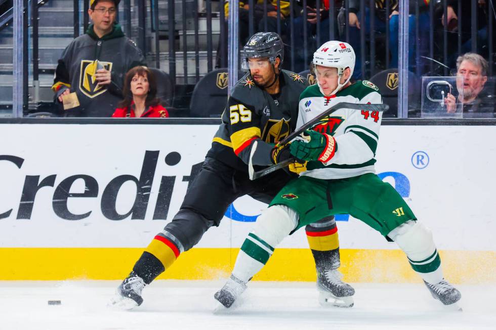 Golden Knights right wing Keegan Kolesar (55) holds Minnesota Wild defenseman Travis Dermott (4 ...