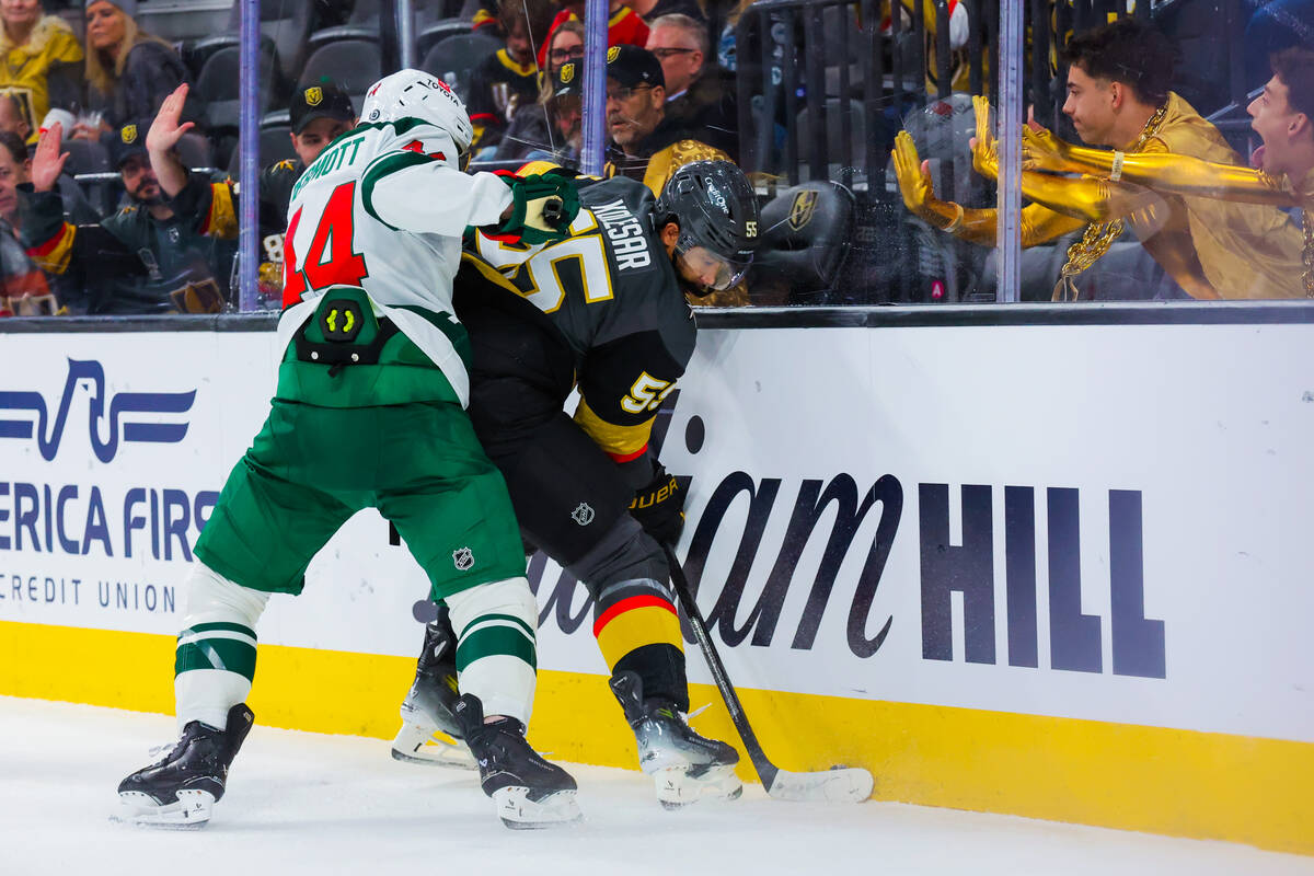 Golden Knights right wing Keegan Kolesar (55) tries to shuffle the puck out from a corner as Mi ...