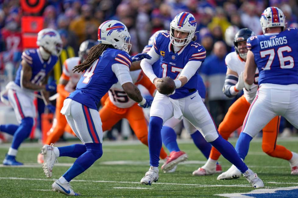 Buffalo Bills quarterback Josh Allen (17) hands off the ball to running back James Cook (4) dur ...