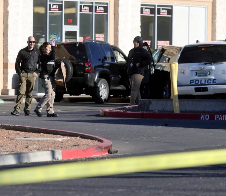 Henderson Police investigate the scene of an officer involved shooting that injured an officer ...