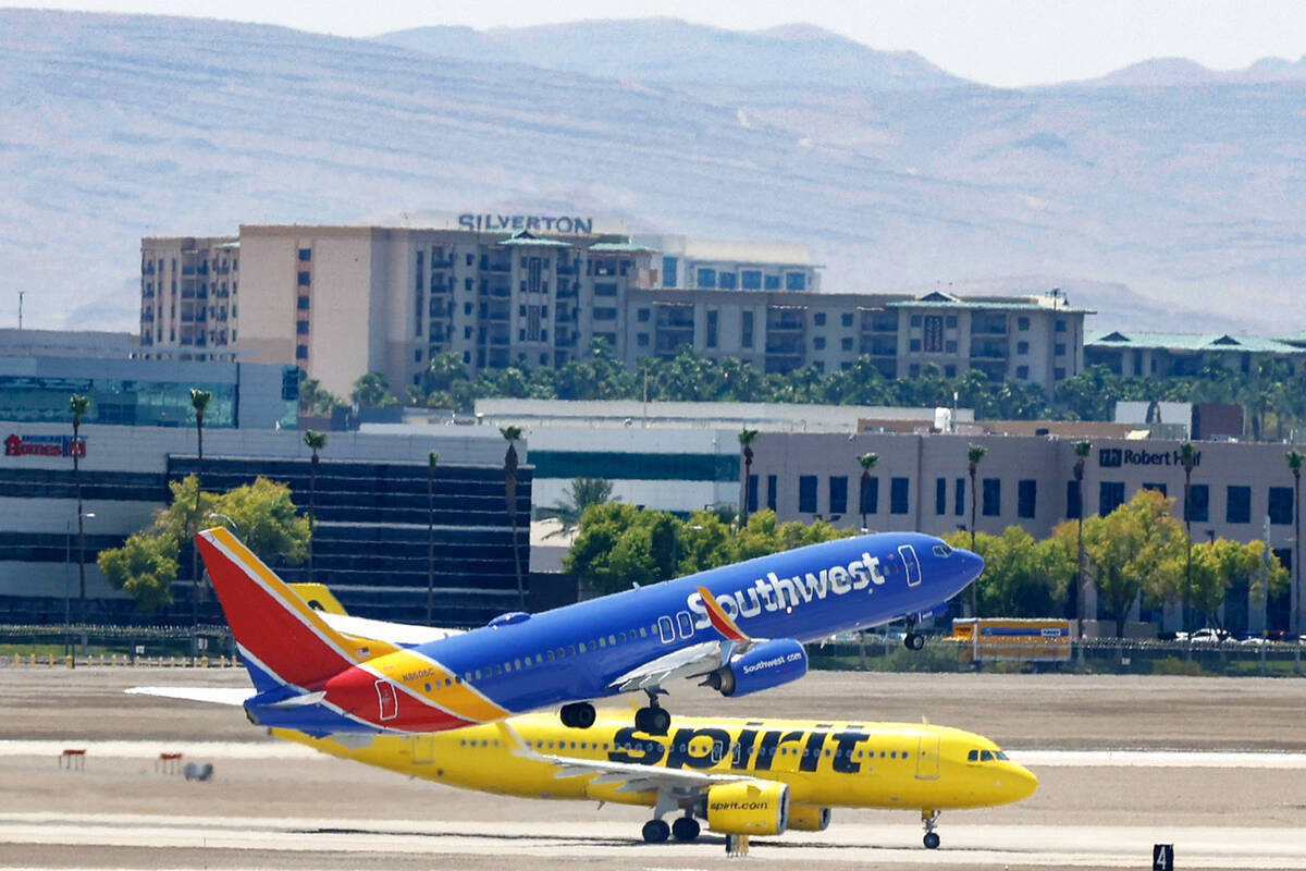 A Southwest Airlines jet takes off as a Spirit Airlines jet taxis at Harry Reid International A ...