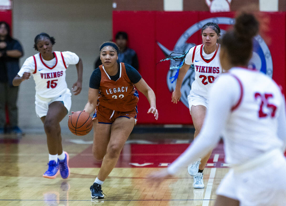 Legacy's Ajalee Williams (32) drives the lane between Valley's Laneice Rodgers (15) and Jennife ...