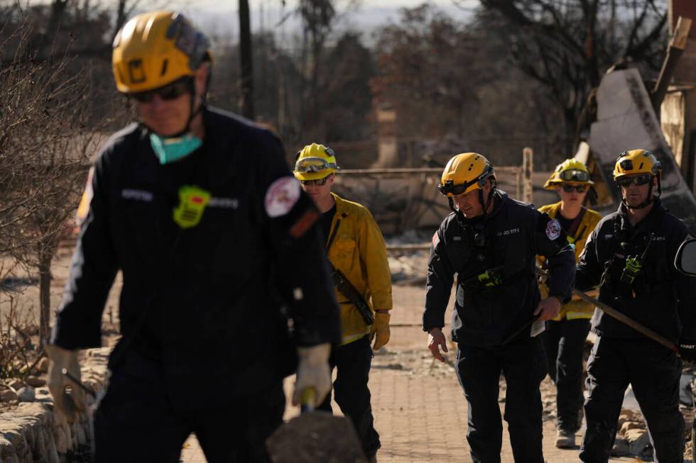 Search and rescue workers dig through the rubble left behind by the Eaton Fire, in Altadena, Ca ...