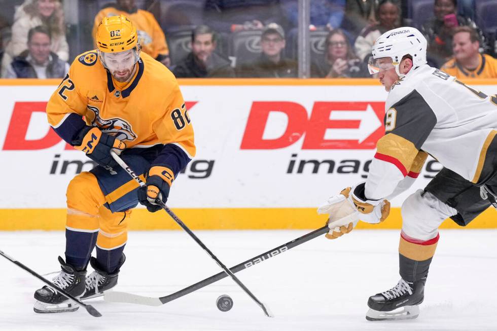 Nashville Predators center Tommy Novak (82) and Vegas Golden Knights center Jack Eichel (9) bat ...