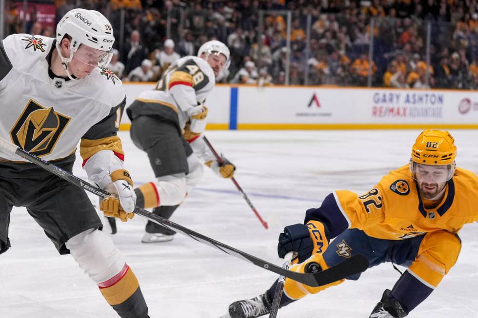 Vegas Golden Knights left wing Pavel Dorofeyev, left, hits the puck past Nashville Predators ce ...