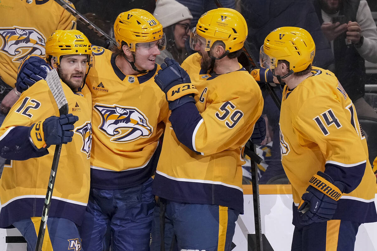 Nashville Predators defenseman Justin Barron (20) celebrates his goal with teammates Vinnie Hin ...