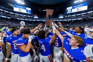 Bishop Gorman hoist their trophy after their 69-7 win over Arbor View for another Class 5A Divi ...