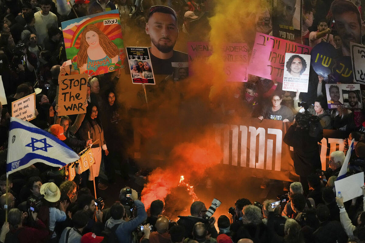 Demonstrators wave flags and signs during a protest demanding a cease-fire deal and the immedia ...