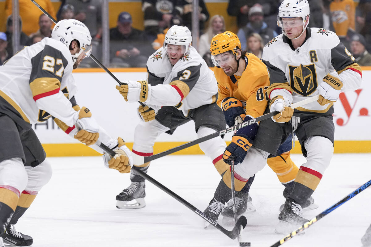 Nashville Predators center Tommy Novak (82) tries to move the puck past Vegas Golden Knights de ...