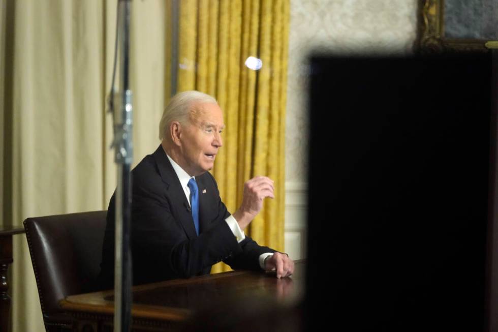 As seen through a window from the Colonnade outside the Oval Office, President Joe Biden speaks ...