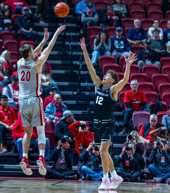 UNLV guard Julian Rishwain (20) shoots over Utah State Aggies guard Mason Falslev (12) during t ...