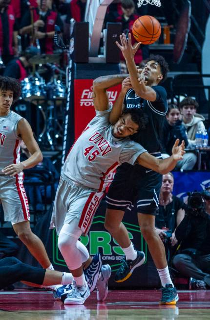 UNLV forward Jeremiah Cherry (45) is run int6o as Utah State Aggies center Aubin Gateretse (21) ...