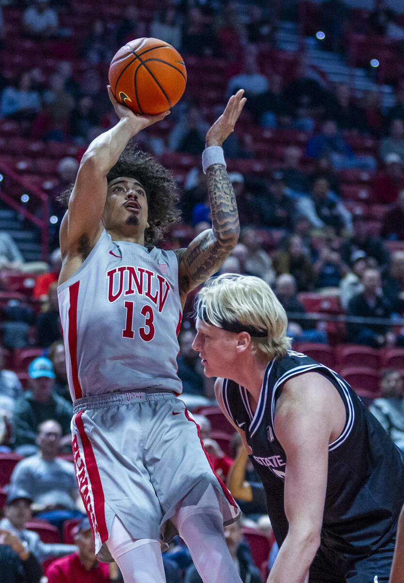 UNLV guard Brooklyn Hicks (13) shoots over Utah State Aggies forward Karson Templin (22) during ...