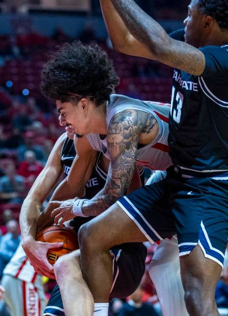 UNLV guard Brooklyn Hicks (13) fights for a loose ball with Utah State Aggies guard Deyton Albu ...