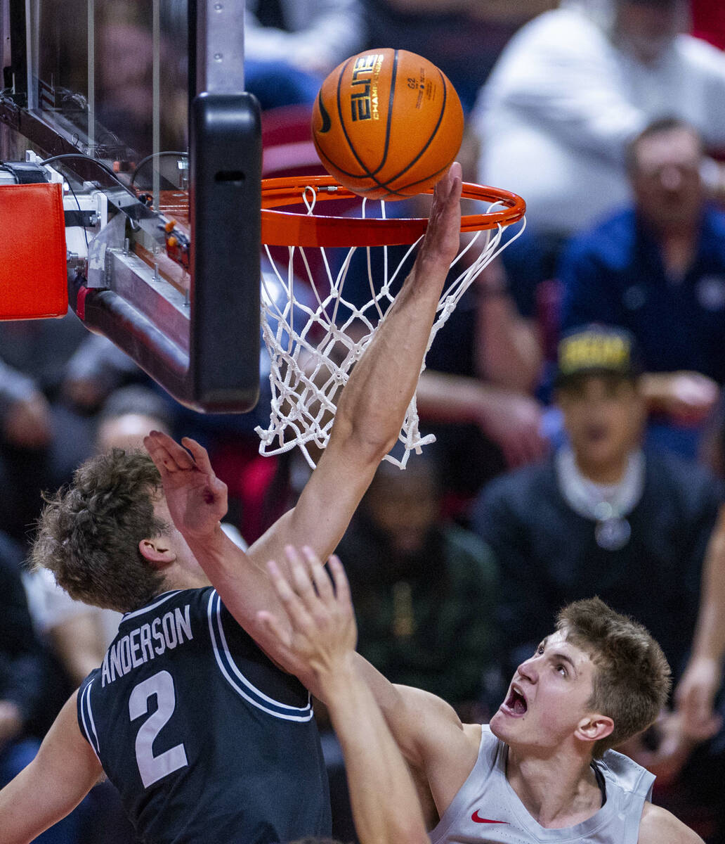 UNLV guard Julian Rishwain (20) gets off a basket just pass the hand of Utah State Aggies forwa ...