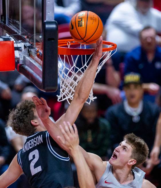 UNLV guard Julian Rishwain (20) gets off a basket just pass the hand of Utah State Aggies forwa ...