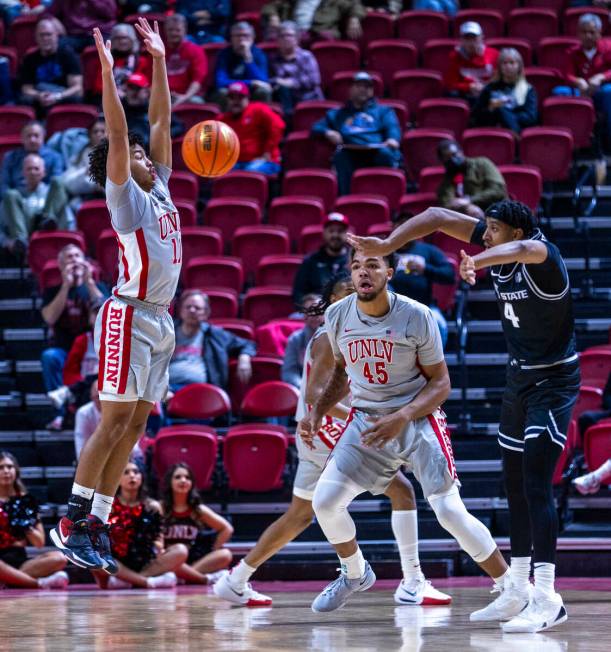 UNLV guard Dedan Thomas Jr. (11) leaps upon for a block attempt as Utah State Aggies guard Ian ...