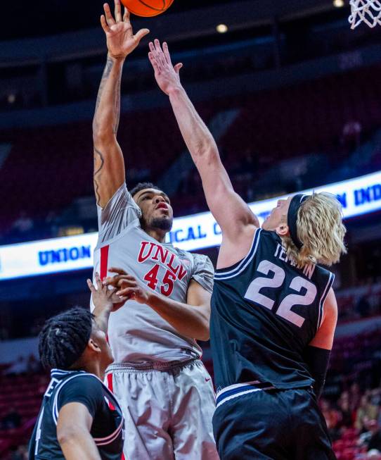 UNLV forward Jeremiah Cherry (45) shoots over Utah State Aggies forward Karson Templin (22) for ...