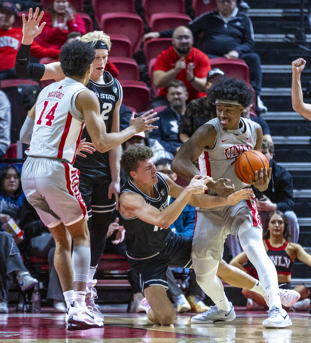 UNLV forward Jacob Bannarbie (12) rips the ball away from Utah State Aggies guard Mason Falslev ...