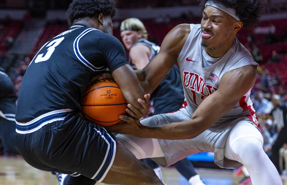 UNLV forward Jacob Bannarbie (12) fights for possession with Utah State Aggies guard Deyton Alb ...