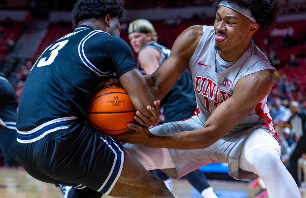 UNLV forward Jacob Bannarbie (12) fights for possession with Utah State Aggies guard Deyton Alb ...