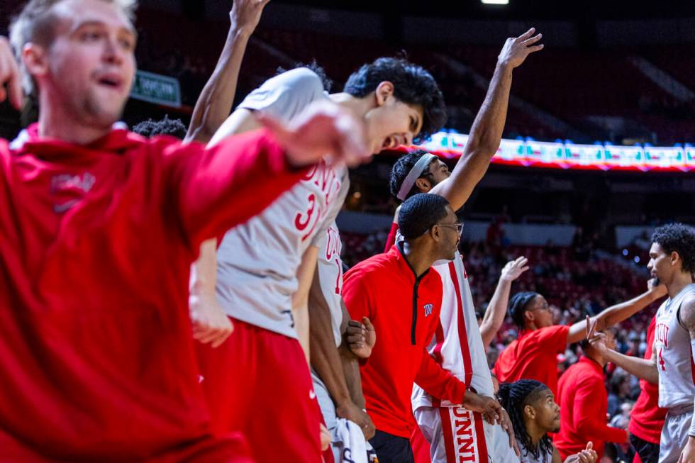 The UNLV bench cheers the team on after a three-point basket against the Utah State Aggies duri ...