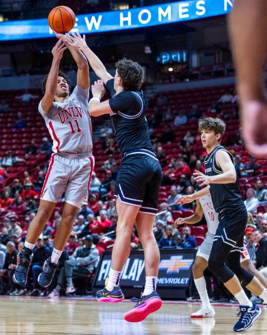 UNLV guard Dedan Thomas Jr. (11) gets off acritical shot for a score over Utah State Aggies gua ...