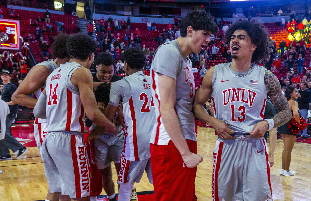 UNLV players celebrate their win against the Utah State Aggies following their NCAA men's baske ...