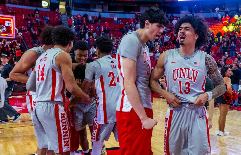 UNLV players celebrate their win against the Utah State Aggies following their NCAA men's baske ...